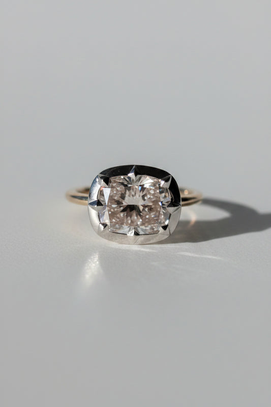 A cushion cut east-west georgian style diamond ring with a rhodium-plated setting, displayed against a white background.